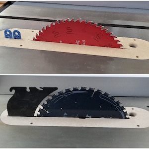 May include: Two different saw blades are shown in a table saw. The top blade is red and the bottom blade is black. Both blades are partially inserted into the table saw.