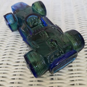 Avon vintage Wild Country aftershave, collectible bottle, race car, blue green, 5 and 1/2 oz contains a full bottle of aftershave
