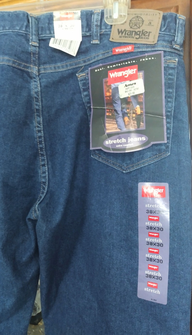 Puede incluir: Un par de pantalones vaqueros azules de mezclilla con una etiqueta de Wrangler. La etiqueta dice "Real. Comfortable. Jeans." y "Stretch Jeans, Extra Comfort". Los pantalones vaqueros son talla 38x30.