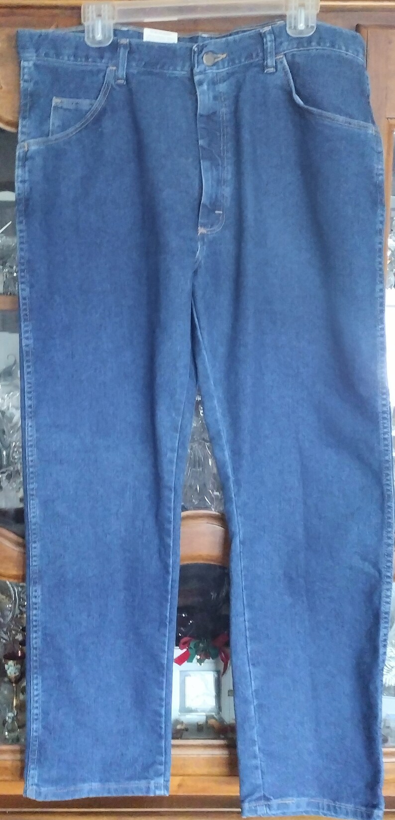 Puede incluir: Un par de pantalones vaqueros azules de mezclilla con cierre de bot&oacute;n y trabillas para cintur&oacute;n.