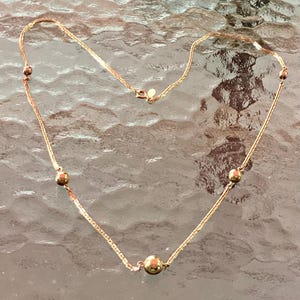Collar largo dorado con cuentas redondas de AVON