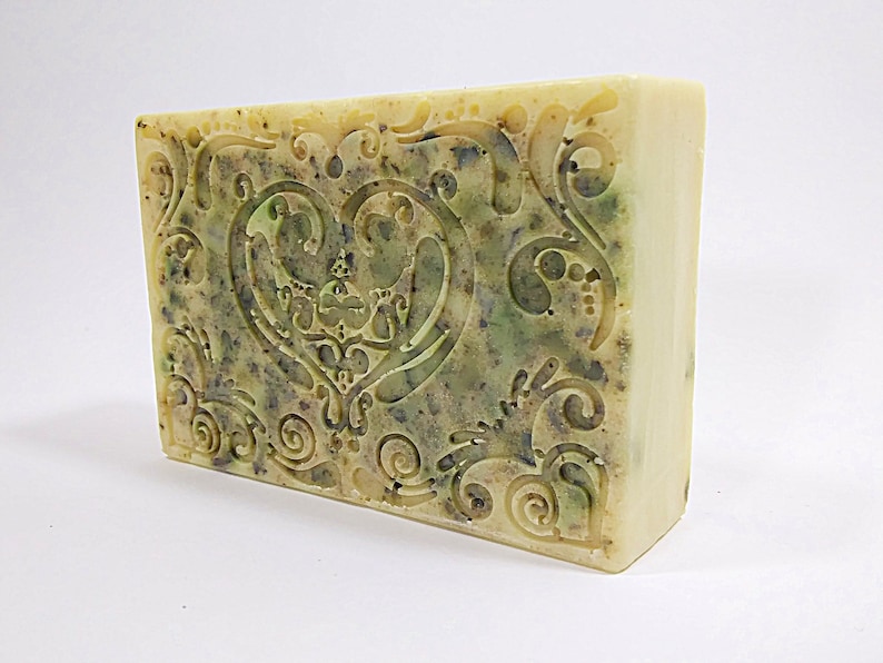 May include: A rectangular bar of soap with a green and white swirl design. The soap has a heart-shaped design in the center with intricate swirls.