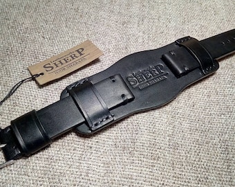 May include: Black leather watch strap with a buckle fastening and the text "Leatherworks Sherp Igor Sharaya" embossed on the strap.