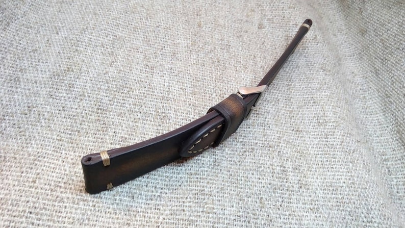 May include: A brown leather watch strap with white stitching and a silver buckle.