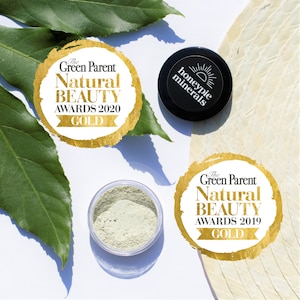 May include: Two gold award seals for "The Green Parent Natural Beauty Awards" with the text "GOLD" on each. The 2020 award is on the left and the 2019 award is on the right. A small jar of green powder is in the centre of the image. A black jar with the text "honeypie minerals" is in the top right corner.
