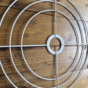 May include: White metal hoop with four concentric circles, ideal for crafting a large wreath or floral arrangement.