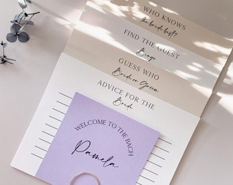 May include: A set of printable bridal shower games with titles including "Who Knows the Bride Best?", "Find the Guest Bingo", "Guess Who: Bride or Groom", and "Advice for the Bride". The games are printed on white cardstock and are ready to be cut out and used at a bridal shower.