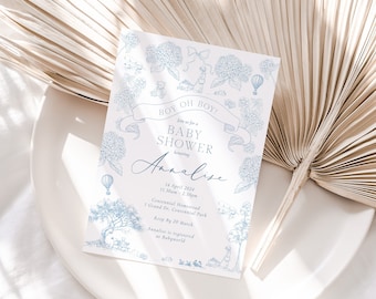 Puede incluir: Una invitación a un baby shower con un diseño floral azul y el texto "BOY OH BOY!". La invitación incluye el nombre "Annalise", la fecha, la hora y los detalles del lugar. El diseño presenta ilustraciones de flores, un globo aerostático y un osito de peluche.