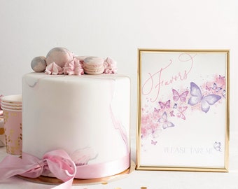 May include: A white cake with pink and gray marbling, topped with pink and white frosting and macarons. A gold frame with a sign that says "Favors" and "Please Take Me" with a watercolor background of pink and purple butterflies.
