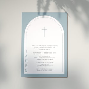 Puede incluir: Una invitación azul claro con un arco blanco y una cruz en la parte superior. El texto dice "Jaden" en una columna vertical e incluye los detalles de una ceremonia de bautizo el sábado 18 de diciembre de 2021 a las 4 pm en la Iglesia Ortodoxa Griega de Gymea. La invitación también incluye los detalles de una celebración que seguirá en The Kyle Bay. RSVP antes del 20 de noviembre de 2021 a Tara en el 0435 572 321.