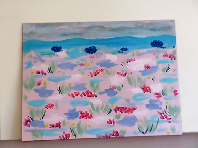 May include: A painting depicting a landscape with a pink background and blue and green brushstrokes. The painting features a blue sky with white clouds and a blue body of water in the distance. There are pink and red flowers scattered throughout the landscape.