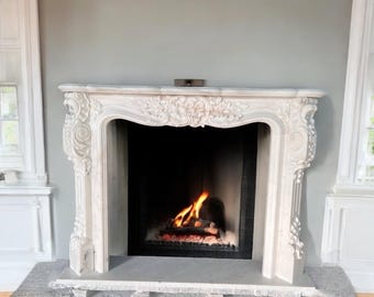 Puede incluir: Chimenea de mármol blanco con detalles ornamentados y un fuego ardiendo en su interior.