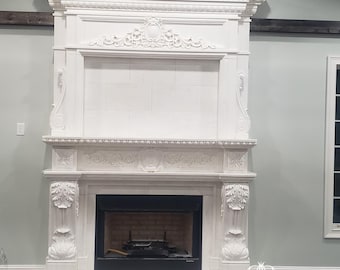 May include: White marble fireplace mantel with intricate carvings and a black fireplace insert. The mantel has a decorative top with a central floral design.