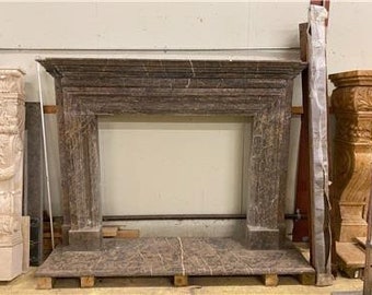 May include: A brown marble fireplace mantel with a rectangular opening. The mantel is sitting on a brown marble base.