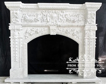 May include: White marble fireplace mantel with intricate carvings and a large arched opening. The mantel is freestanding and has a decorative base.
