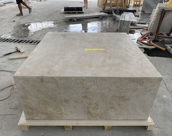 May include: A large, rectangular, light beige stone slab with a rough, textured surface. The slab is sitting on a wooden pallet. The text "FROMEUROPTTOYOU" is visible on the slab.
