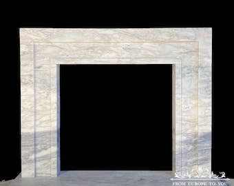 May include: A white marble fireplace mantel with a rectangular opening. The mantel has a simple, modern design with clean lines.
