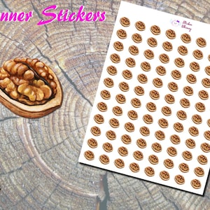 May include: A sheet of planner stickers featuring a walnut design. The stickers are brown and tan, with a detailed illustration of a walnut. The image also includes a single, larger walnut illustration and the text "Planner Stickers".