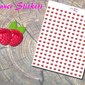 May include: Planner stickers featuring a sheet of small red raspberry stickers with green leaves. Two large raspberry stickers are on the left. The stickers are on a wood grain background. The text "Planner Stickers" is at the top.