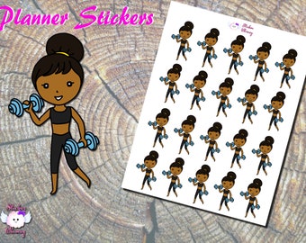 May include: A sheet of planner stickers featuring a cartoon illustration of a woman with brown skin lifting weights. The woman is wearing a black sports bra and black leggings. The stickers are on a white background.