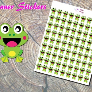 May include: A sheet of planner stickers featuring a repeating pattern of green frogs with big eyes, pink cheeks, and yellow bellies. The frogs are smiling with their mouths open. The stickers are on a white background.