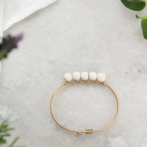 Armband med lavapärlor i guld- eller silvertråd i svart, vitt eller franskblått.