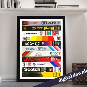 Puede incluir: Una impresión enmarcada de una pila de cintas de video VHS vintage. Las cintas están dispuestas verticalmente y presentan varias marcas y etiquetas, incluidas JVC, Scotch y Kodak. La impresión es un recordatorio nostálgico de la era del video casero.