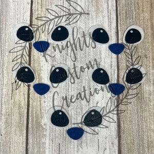 May include: A set of felt eyes and noses in various sizes. The eyes are white with black pupils and the noses are blue. The felt pieces are arranged on a wooden surface.