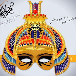 May include: Gold paper mask with a detailed design of a pharaoh's headdress, including a cobra, feathers, and geometric patterns. The mask has a black eye mask with a gold design. The text "Maskin Paper Wonders Store" is visible in the top left corner. The text "More in our store" is visible in the top right corner.