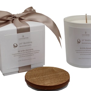 May include: A white candle with a wooden lid in a white box with a brown satin ribbon. The candle and box have a label that says "24th Wedding Anniversary" and "Mr & Mrs Kennedy".