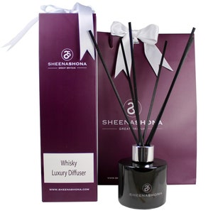 May include: A black glass bottle with a silver cap and black reeds, a purple box with the text "Whisky Luxury Diffuser" and the logo "Sheenashona Great Britain", and a purple gift bag with the logo "Sheenashona Great Britain".