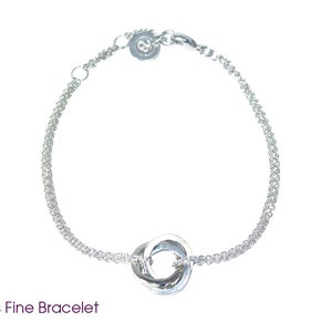 Puede incluir: Pulsera de plata de ley con círculos entrelazados. La pulsera es delicada y presenta una cadena fina.