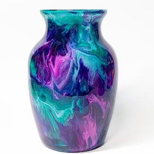 May include: A ceramic vase with a swirling abstract design in shades of teal, purple, and pink.