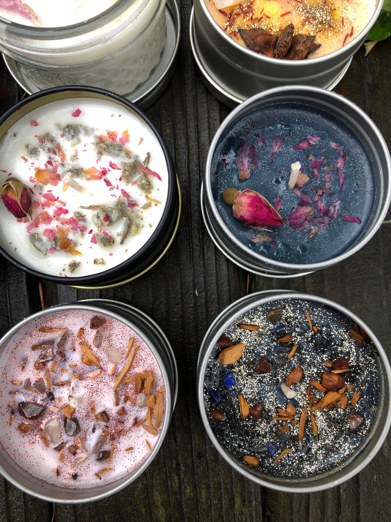 Pu&ograve; includere: Cinque candele profumate diverse in barattoli di metallo. Le candele sono di colori diversi e hanno vari elementi decorativi, tra cui fiori secchi, glitter e cristalli.