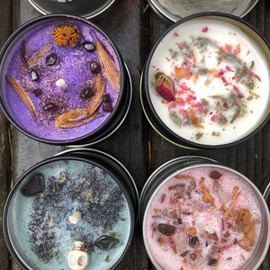 Pu&ograve; includere: Quattro piccole candele in barattoli di metallo con vari elementi decorativi. Le candele sono viola, bianche, blu e rosa. Gli elementi decorativi includono fiori secchi, glitter e piccole pietre.
