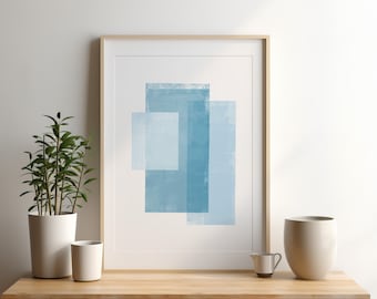 May include: A framed abstract print with a light blue geometric design. The print is in a wooden frame and is hanging on a white wall. There are two white ceramic mugs and a small silver pitcher on a wooden table in front of the print.