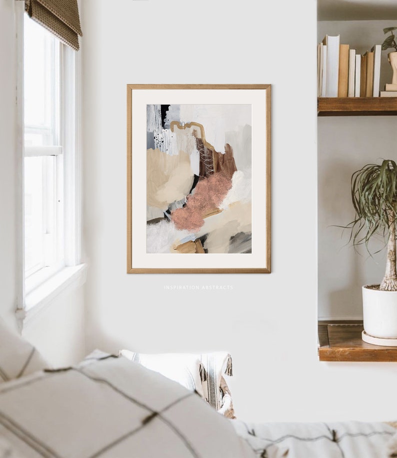 K&ouml;nnte beinhalten: Abstrakter Kunstdruck in einem Holzrahmen mit einem Farbschema in Beige, Braun und Rosa. Der Druck tr&auml;gt den Titel "Inspiration Abstracts".