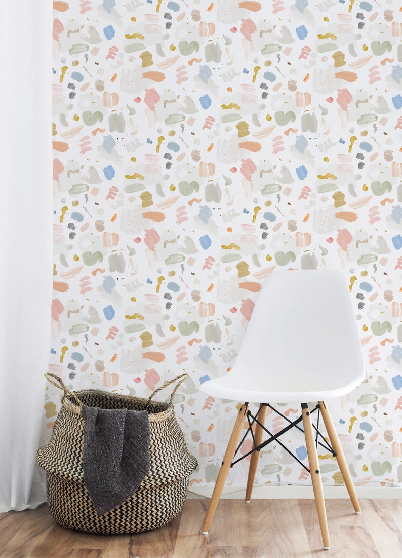 May include: A white chair with wooden legs sits in front of a wall covered in a colorful abstract wallpaper. The wallpaper features a repeating pattern of brushstrokes in shades of pink, blue, green, and yellow.