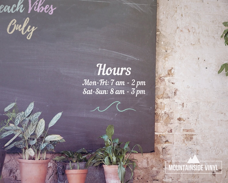 Puede incluir: Un letrero de pizarra con las palabras "Beach Vibes Only" y "Hours" escritas en &eacute;l. El horario de atenci&oacute;n es el siguiente: Lun-Vie: 7 am - 2 pm, S&aacute;b-Dom: 8 am - 3 pm. El letrero est&aacute; colgado en una pared de ladrillo con una peque&ntilde;a planta en una maceta delante de &eacute;l.