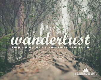 May include: A scenic photograph featuring the word "wanderlust" in a stylized font, set against a blurred backdrop of a forest. The image includes a fallen log covered in leaves, with the text "MOUNTAINSIDE VINYL" at the bottom.