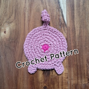 May include: A pink crocheted pig with a pink tail and a pink star on its backside. Crochet Pattern.