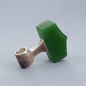 Side view of a handcrafted silver Mjolnir pendant with natural nephrite jade.