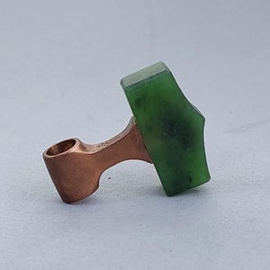 Side view of a bronze Mjolnir pendant featuring hand-carved natural nephrite jade.