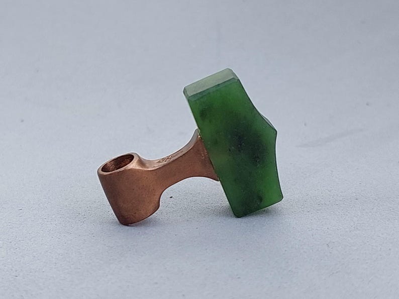 Side view of a bronze Mjolnir pendant featuring hand-carved natural nephrite jade.