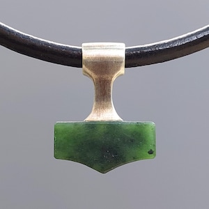 Silver Mjolnir pendant with natural nephrite jade displayed on a leather cord.