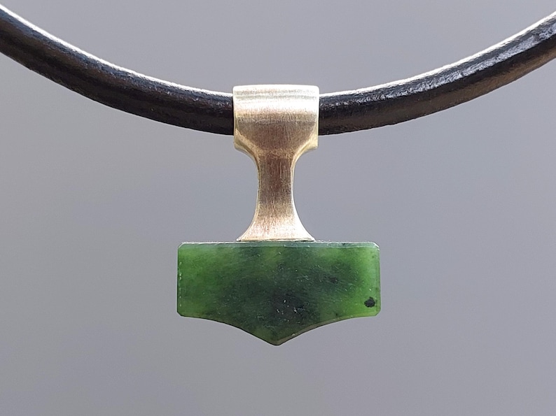 Silver Mjolnir pendant with natural nephrite jade displayed on a leather cord.