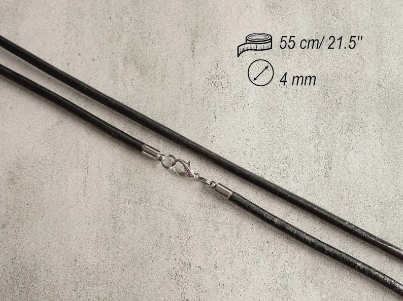 May include: A black cord necklace featuring a silver-toned lobster claw clasp. The cord has a diameter of 4 mm and a total length of 21.5 inches, as indicated by the text and icons printed on the image.