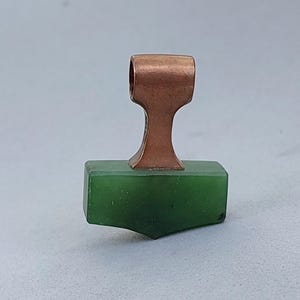 Front view of a handcrafted bronze Mjolnir pendant with natural nephrite jade.