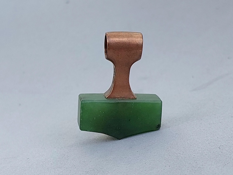 Front view of a handcrafted bronze Mjolnir pendant with natural nephrite jade.