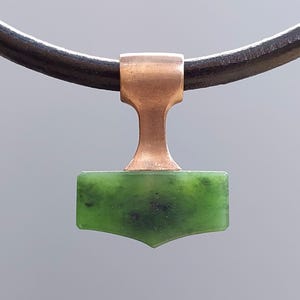 Bronze Mjolnir pendant with natural nephrite jade displayed on a leather cord.